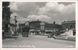 Street Scene with businesses, cars, and statue Postcard