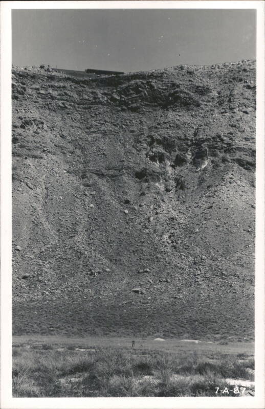 Rocky Hillside Landscape with Distant Structure and Sparse Vegetation Winslow Arizona