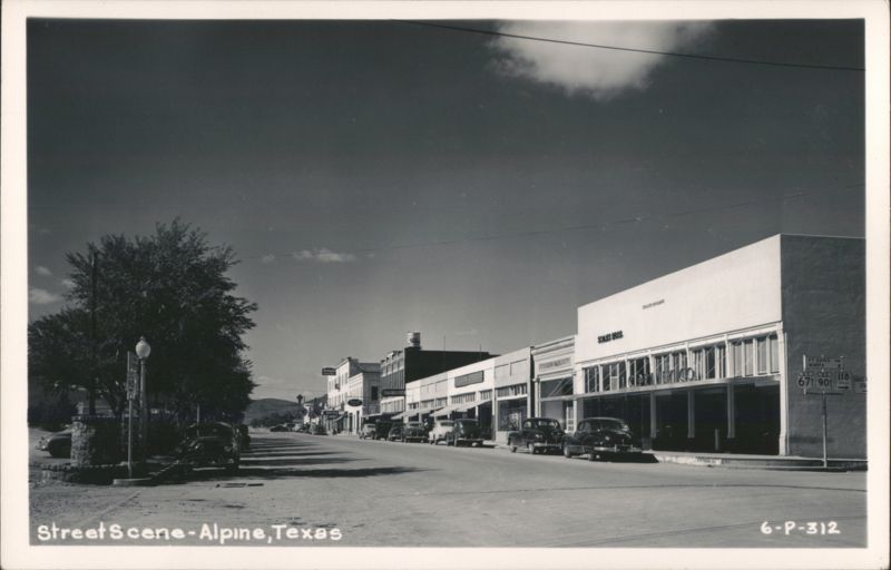 Main Street with Businesses, Parked Cars, and Water Tower Alpine Texas