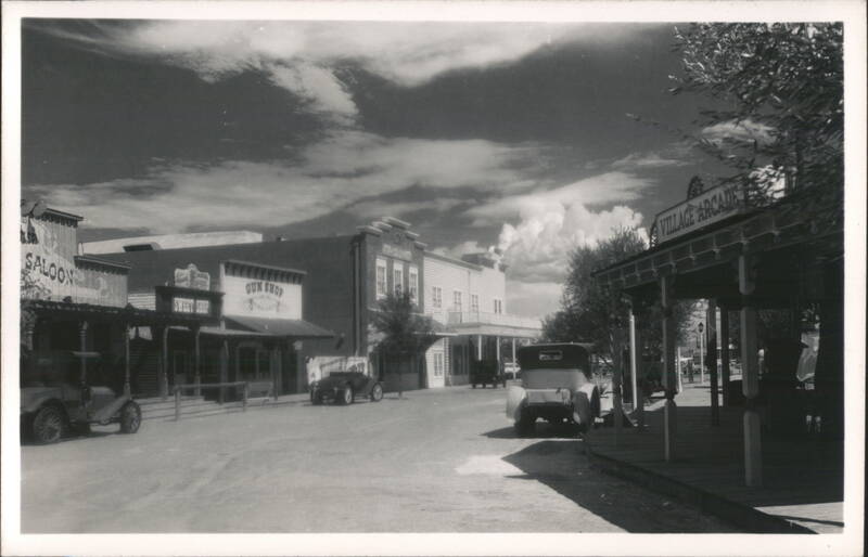 Street scene: Saloon, Gun Shop, Village Arcade, and vintage automobiles