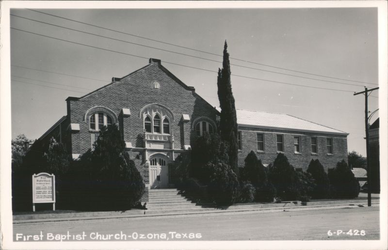 First Baptist Church, brick building with arched windows and tall trees Ozona Texas