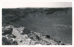 Large desert crater viewed from its rocky rim Postcard