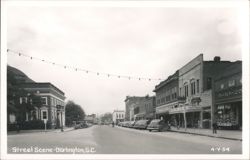 Street Scene with Dome Building, Businesses, Cars, and String Lights Postcard
