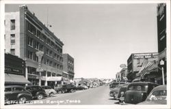 Street scene with Gholson Hotel, Paramount Hotel, and parked cars Postcard