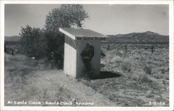 Mr. Santa Claus building with Santa figure in desert landscape Postcard