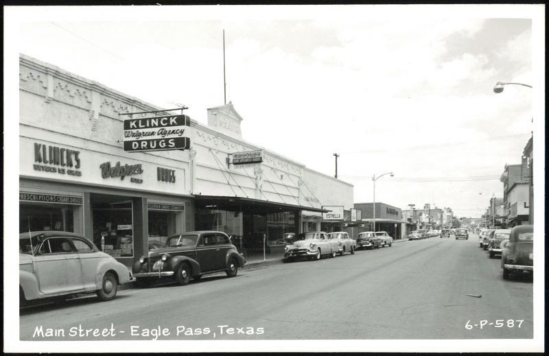 Main Street with Klick's Walgreen Agency, Estrella, and parked cars Eagle Pass Texas