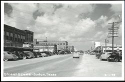 Downtown Street Scene with Vintage Cars and Businesses Postcard