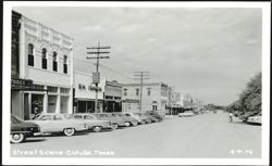 Downtown Street Scene with Parked Cars and Businesses Postcard