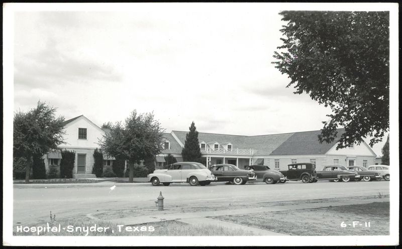 Hospital building with cars parked on street