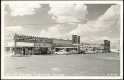 Downtown Street Scene with Shops and Parked Cars Postcard