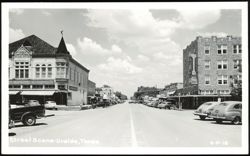 Downtown Street Scene with Businesses and Parked Cars Postcard