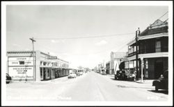 Main Street View with Corner Drug Store and Businesses Postcard
