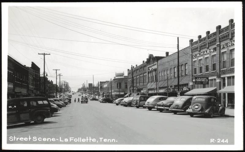 Downtown Street Scene with Parked Cars and Storefronts