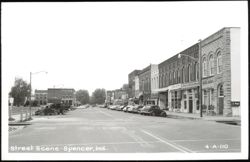 Downtown Street Scene with Stores and Parked Cars Postcard