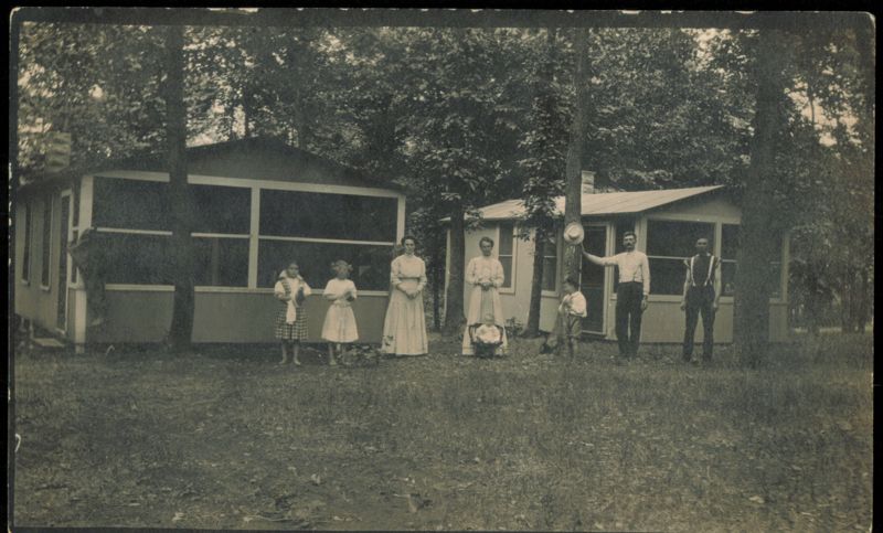Family Posing in Front of Two Screened-In Cabins Family Portaits