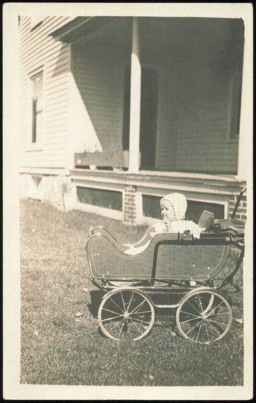 Baby in Bonnet Sitting in Carriage Outside House Babies