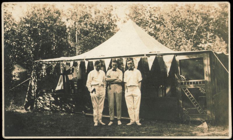 Three Men Standing in Front of a Tent at Camp Iris