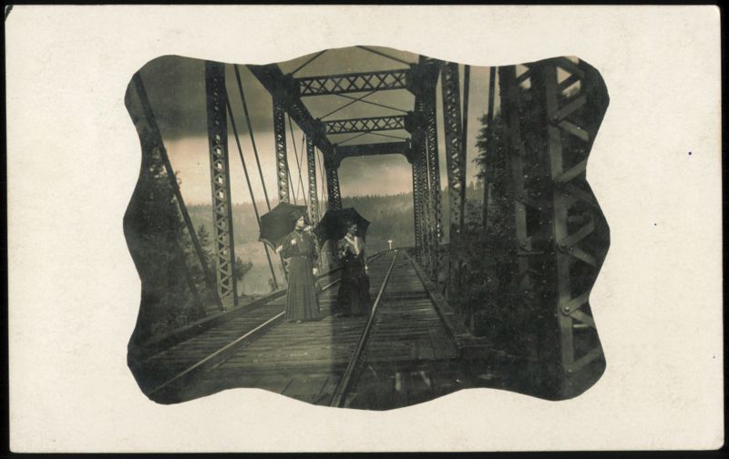 Two Women with Umbrellas on St. Joe River Bridge, Idaho Saint Joe