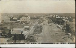 Street Scene with A. Mitchell Land Office Postcard