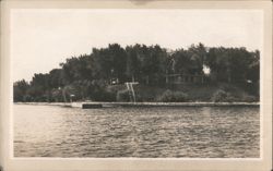 Sodus Point, NY - Waterfront with Dock & Hillside Building Postcard
