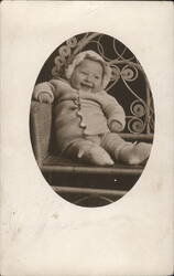 Smiling Baby in Wicker Chair, Bonnet & Knitted Outfit Postcard