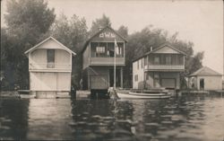 Boathouses on Water with 'OWL' Sign Postcard