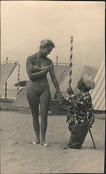 Woman in Bikini Interacting with Little Person on Beach Postcard