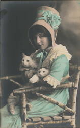 Woman in Aqua Hat and Dress Holding Two White Cats in Twig Chair Postcard