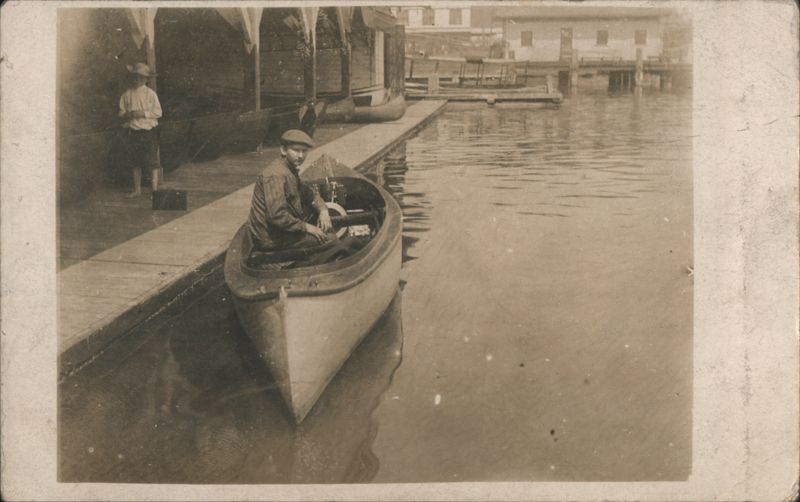 Man Seated in Small Motorboat at Wooden Dock Transportation