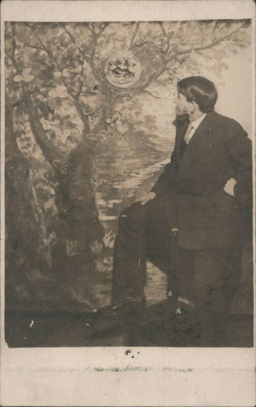 Studio Portrait Man Seated with Smiling Moon Face in Tree