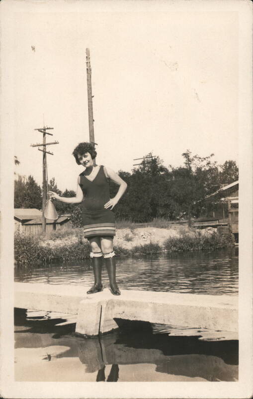 Flapper Beulah in 1920s Swimsuit Holding Megaphone on Concrete Wall