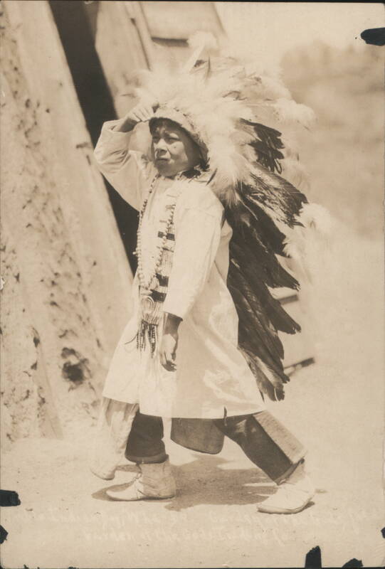 Young Native American Boy in War Bonnet Shading Eyes