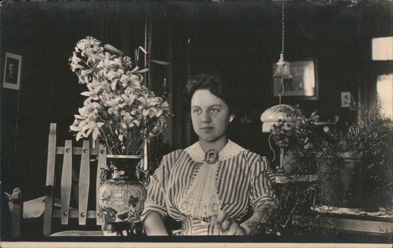 Young Woman in Striped Blouse with Vase of Lilies Portrait