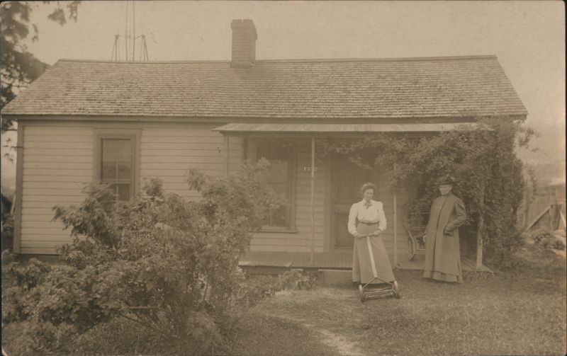 Woman Mowing Lawn with Manual Reel Mower outside House