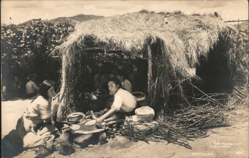 Indigenous Women Making Tortillas Under Thatch Shelter