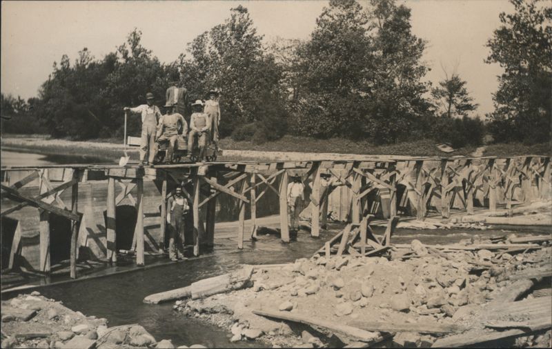 Construction Crew on Wooden Dam Structure with Rail Cart
