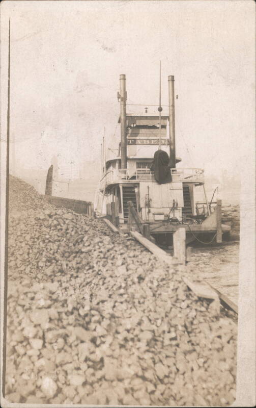 River Steamboat Taber Docked Next to Large Coal Pile
