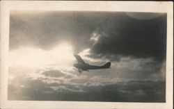 Early Biplane Silhouette in Flight Against Cloudy Sky Postcard