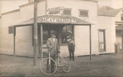 W.N. Carroll Grocery & Meat Market Storefront, Man with Bicycle Postcard