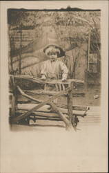 Curly-Haired Child in Hat Standing on Rustic Wooden Bench Postcard