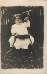 Smiling Baby in High Chair Holding Stuffed Toy Postcard