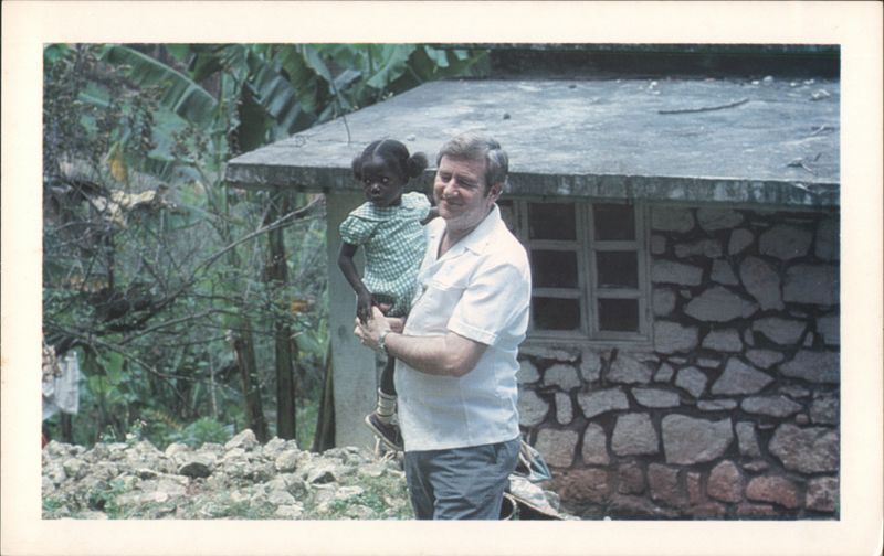 Jerry Falwell Holding Young Girl in Tropical Setting
