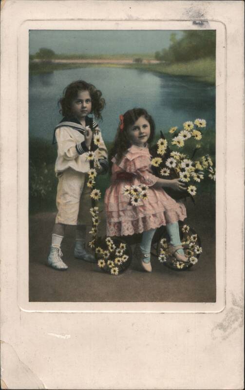 Two Children in Sailor Suit and Pink Dress with Daisies by a River