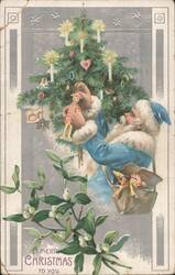 Santa Claus Decorating Christmas Tree with Toys and Mistletoe Postcard