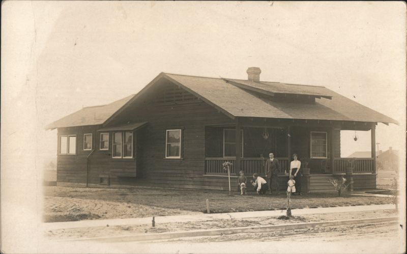 Family in front of wooden house with porch