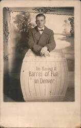 Man Posing with Barrel, 'Barrel of Fun' in Denver Postcard