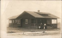 Family in front of wooden house with porch Postcard