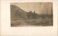 Men on vehicle in barren mountainous landscape Postcard