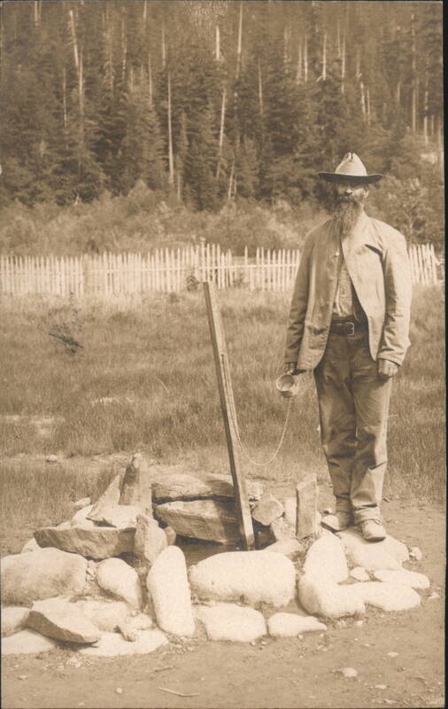 Man with Beard Standing by Stone Well Men