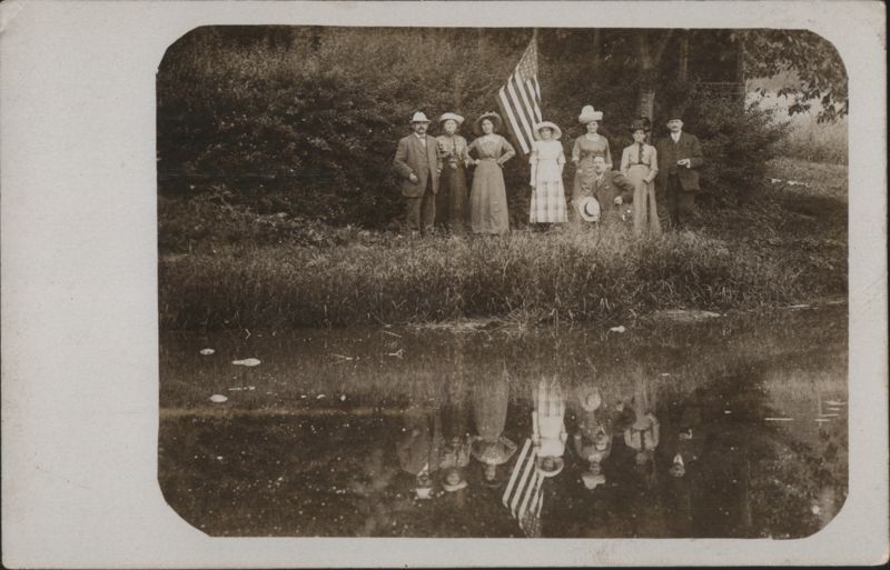 Group of People Posing with American Flag by Water
